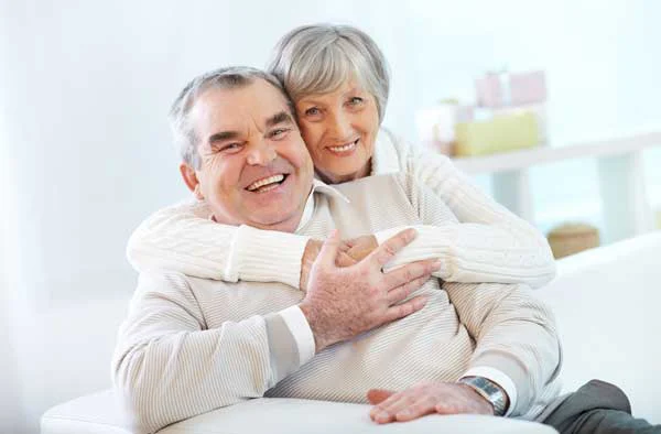 Coppia di anziani sorridenti abbracciati